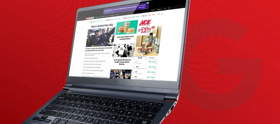 Laptop displaying a news website against a red patterned background